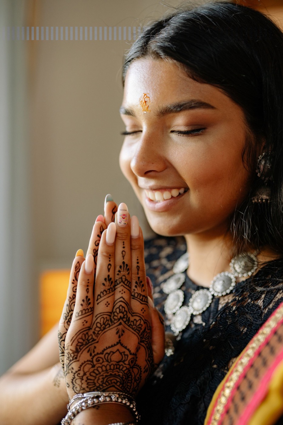 Profesional de la belleza indocaribeña con arte de uñas y henna